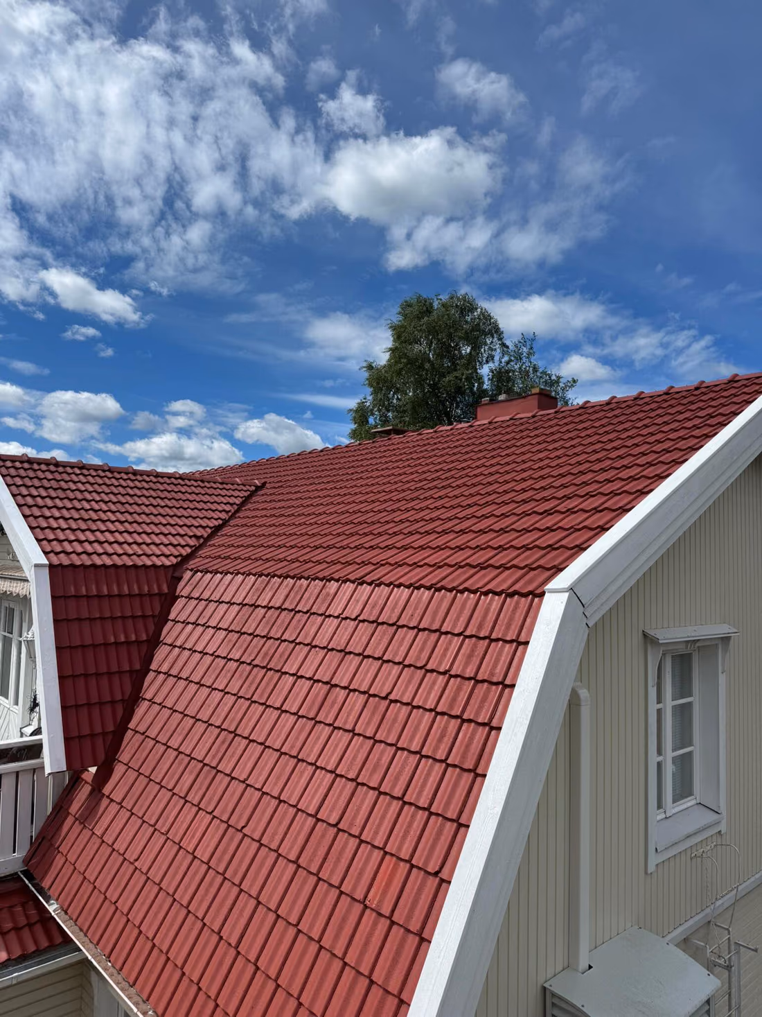 Sama tiilikatto pinnoituksen jälkeen, syvän punainen ja tasainen pinta